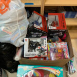 A box of toys. Somewhat visible on the sides of this box are bags of toys and a toy box.