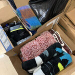 Two boxes containing blankets and another box containing socks